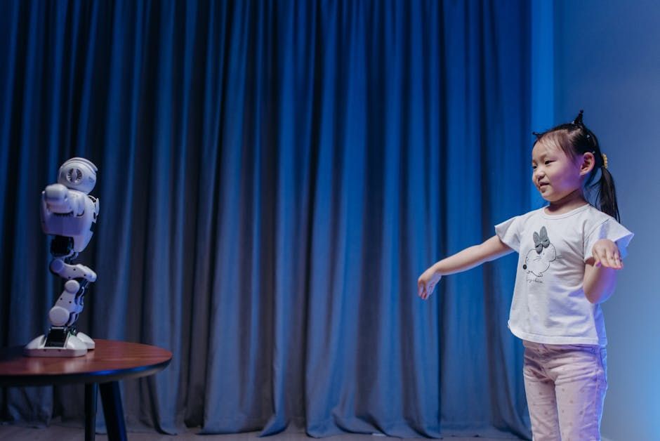 A young girl playfully interacts with a humanoid robot in a modern indoor setting.