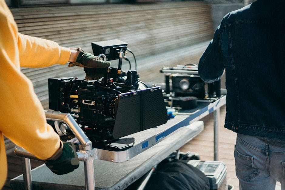 Close-up view of professional film equipment on a movie set with crew members preparing for filming.